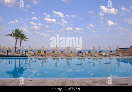 Beautiful big swimming pool with sunbeds in a hotel on a sunny summer ...