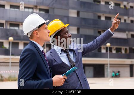 Architects talking about project documentation on construction plant Stock Photo