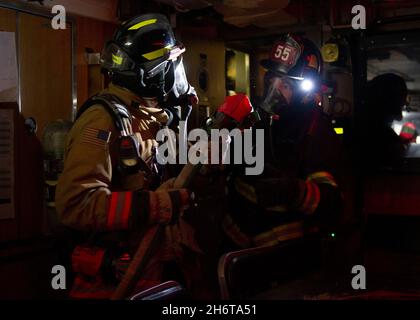 211110-N-ME396-1459 GROTON, Conn. (Nov. 10, 2021) Firefighters coordinate during a firefighting exercise in the wardroom aboard the Los Angeles-class nuclear-powered fast-attack submarine USS Cheyenne (SSN 773). The training evolution simulated a fire in a crew berthing similar to the fire aboard USS Miami (SSN 755) in 2012 and was designed to ensure civilian fire departments would be able to support their Navy counterparts should they ever be called. (U.S. Navy photo by Mass Communication Specialist 2nd Class Tristan B. Lotz/Released) Stock Photo