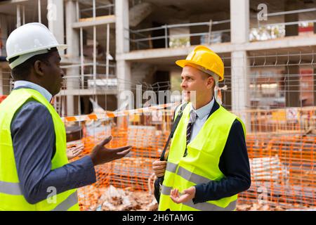 Two engineers standing on construction site and talking Stock Photo