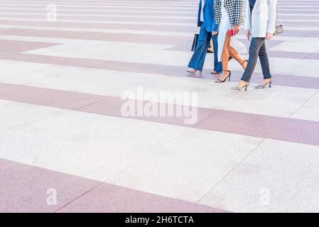 three business women walking across a pedestrian crossing Stock Photo