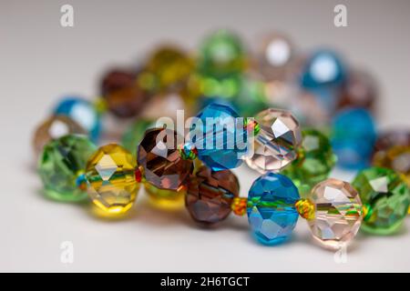 Macro abstract texture background of a string of defocused colorful glass beads on white background Stock Photo