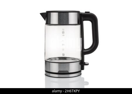 Glass, electric, modern transparent kettle on a white background. Close-up. With a reflex on the table Stock Photo