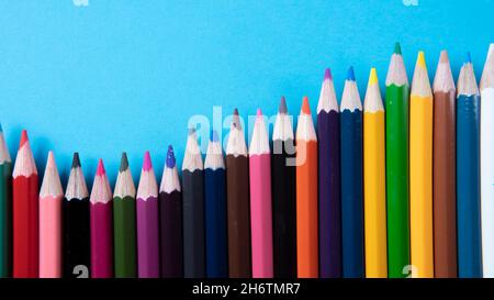 A bunch of color pencil on a blue background. Selective focus on the pencil color Stock Photo