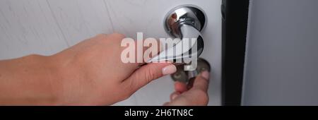 Door lock is opened by woman hand closeup Stock Photo