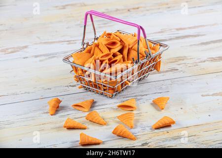 Portion of cone shaped snack tornado shaped crackers. Yellow spicy potato cone chips texture or Background of corn cone. Stock Photo