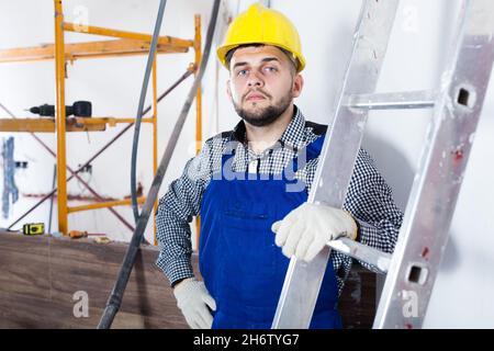 Portrait of smiling workman which is doing repair Stock Photo
