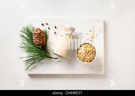 Vegan cedar nut milk in bottle on white background. Plant based milk replacer and lactose free. Healthy vegetarian drink. View from above. Stock Photo