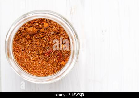 Bright Georgian Svan salt in a glass jar stands on a white wooden table Stock Photo