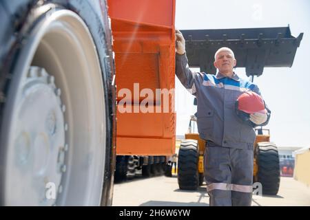 Driver yellow big truck on coal at open pit mining. Concept industry man worker. Stock Photo