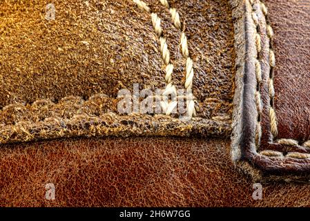 Macro background made of brown natural leather with white stitches all around. Stock Photo
