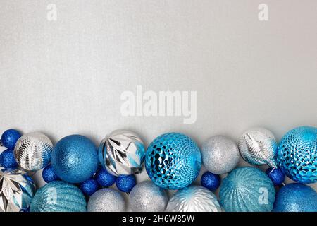 Frame made from blue Christmas baubles on a silver colored background. Stock Photo