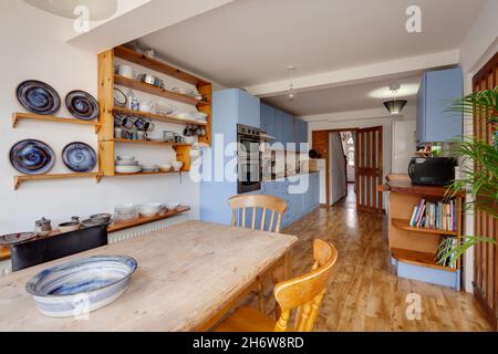 Cambridge, England - August 21 2019: Kitchen and dining room within english victorian era home including dining table and fitted cupboards Stock Photo