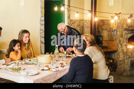 Happy latin family cooking together during dinner time - Focus on grandfather face Stock Photo
