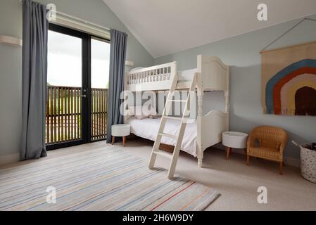 Dry Drayton, England - August 2 2019: Childs bedroom space with bunk bed including ladder decorated in blue and white Stock Photo