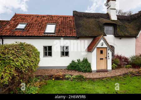 Kedington, Suffolk, November 19 2019: Traditional quaint British cottage in England. Thatched and pan tiled roof with entrance porch and garden. Stock Photo