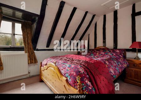 Kedington, Suffolk, November 19 2019: Bedroom in very old traditional British cottage with an abundance of exposed timbers Stock Photo