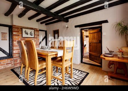 Kedington, Suffolk, November 19 2019: Cottage Dining room within traditional British cottage with oak dining table and chairs, exposed beam ceiling Stock Photo