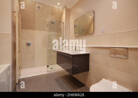 Clavering, England -  April 6 2020: Well lit partially tiled shower room wc within recently completed new home prior to sale Stock Photo