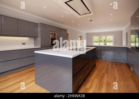 Clavering, England -  April 6 2020: New Home luxury Kitchen interior with comprehensive range of grey coloured units with built in appliances Stock Photo