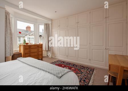 Cambridge, England - August 15 2019: Generous sized bedroom with a wall of built in wardrobes inside victorian era British home Stock Photo