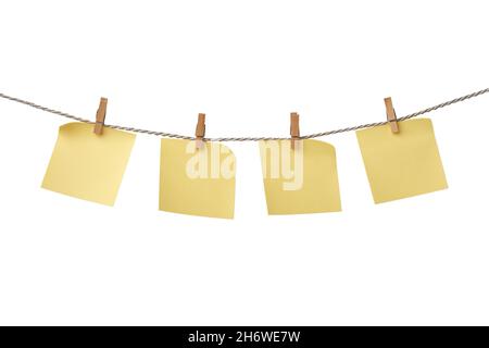 Four yellow paper blank notes hanging on the rope isolated on white background Stock Photo