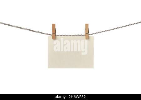 Old paper blank card hanging on the clothesline isolated on white background Stock Photo