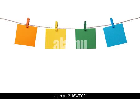 Four multicolored paper blank notes hanging on the rope with wooden clothespins isolated on white background Stock Photo