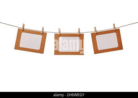 Three craft paper photo frames hanging on the rope with wooden clothespins isolated on white background Stock Photo