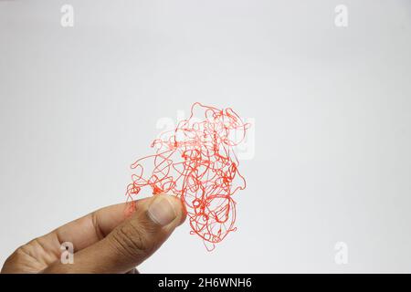 PLA plastic filaments held in hand left out from overhanging while 3d printing process, waste filaments to be recycled Stock Photo