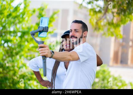 two friends of different ethnicities taking a selfie with the mobile Stock Photo