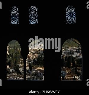 Roma quarter of the City of Granada, Andalusia, Spain, viewed through Moorish windows in the 14th century Nasrid Palaces complex of the Alhambra Palace Stock Photo
