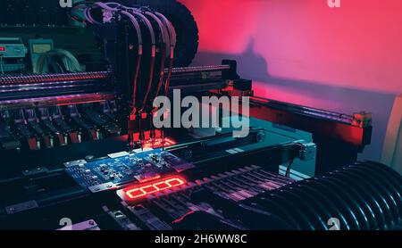 Automatic production of computer chips by SMT Pick and Place machine. Automatic SMT Pick and Place machine picks elements up and places them onto the motherboard. Automation of manual work. Stock Photo