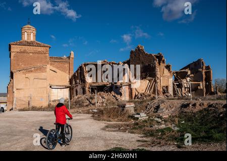 A man with a bike looks at the ruins of Belchite. The town of Belchite is known for one of the symbolic battles of the Spanish Civil War, the Battle o Stock Photo