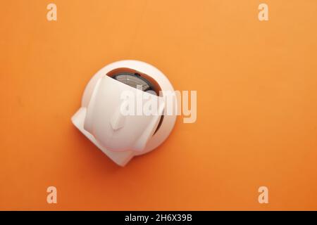 CCTV security camera operating on light orange background  Stock Photo
