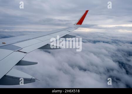 Classic image through aircraft window onto wing. Flight view over clouds Stock Photo