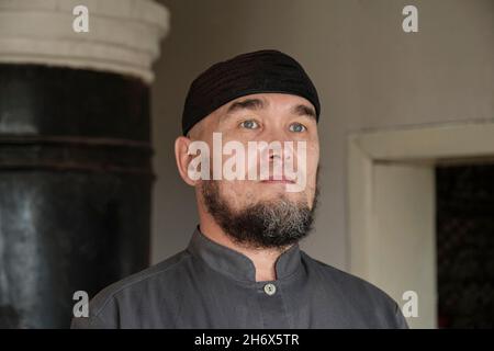Close up portrait of serious senior asian muslim man wearing skullcap. Stock Photo