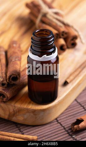 concept of natural cosmetics, glass bottle with oil, cinnamon sticks Stock Photo