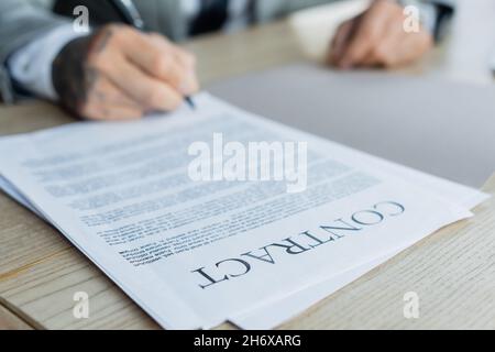 cropped view of blurred businessman signing contract in office Stock Photo