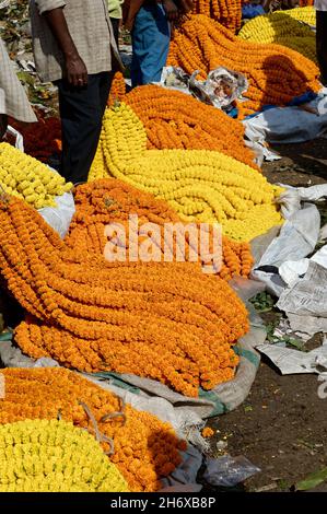 Traders in the Howrah flower market with marigolds and puja offerings, Kolkata, India Stock Photo