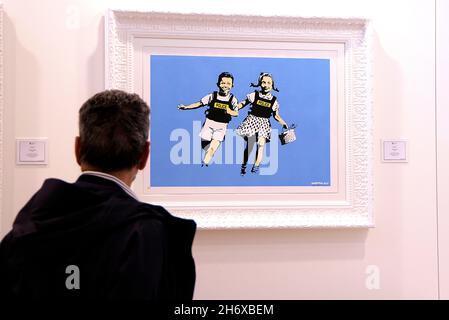 Rome, Italy. 18th Nov, 2021. A visitor observes a work by the artist Banksy during the opening of the exhibition market.The first edition of 'Roma Arte in Nuvola' at the New Congress Center known as 'La Nuvola' in Rome. (Photo by Vincenzo Nuzzolese/SOPA Images/Sipa USA) Credit: Sipa USA/Alamy Live News Stock Photo