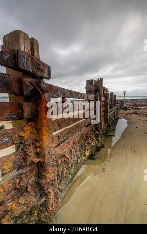 rusty corroded breakwater or groyne on the beach on the isle of wight coastline, isle of wight shoreline decaying old rusty breakwater, corrosion rust Stock Photo
