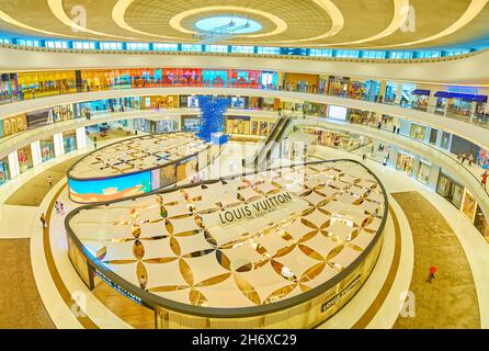 DUBAI, UAE - MARCH 3, 2020: Interior of large square of Dubai Mall with fashionable boutiques of Louis Vuitton in the middle, on March 3 in Dubai Stock Photo