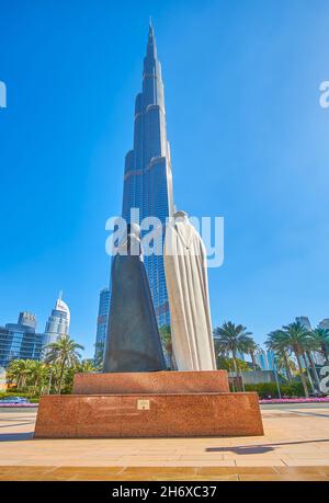 The Burj Khalifa skyscraper and the Arabic Couple Statue in downtown ...