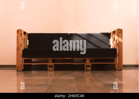 photo of bench made with pallets illuminated by solar rays entering through window Stock Photo