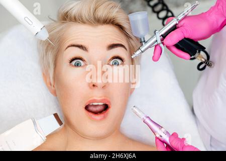 Amazed caucasian adult woman with perfect skin with a wide range of modern beauty procedures. Skin care. Anti-aging treatment and face lifting. Stock Photo