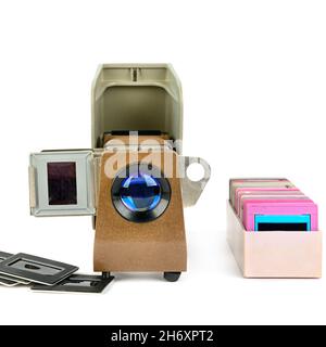 Old slide projector and set of slides isolated on white background. Retro equipment. Stock Photo