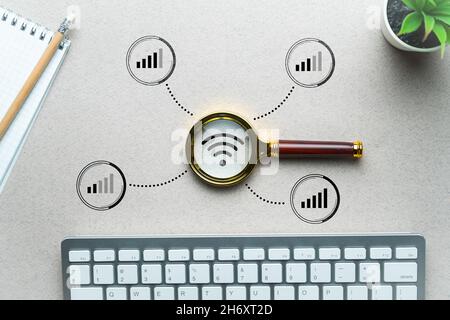 WiFi home network search concept. Magnifying glass on the table. Stock Photo