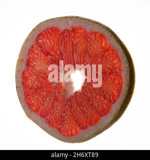 The photo shows a round piece, a pomelo slice. The inside of the exotic  fruit is pink in color, on the outside there is a yellow-green peel. Citrus  si Stock Photo 