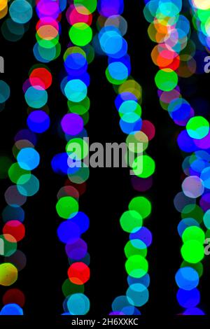 Colored blurred lights, defocused background. New Year Christmas background with multicolored blurred lights. Stock Photo